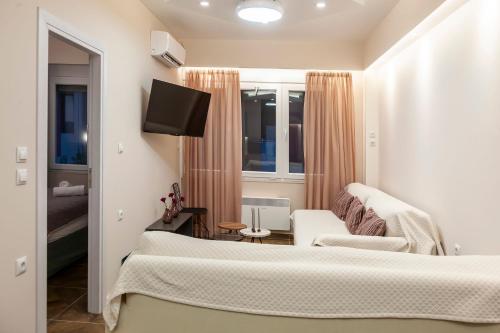 a room with a bed and a couch and a tv at Ioannina Central Apartment by SuperhostHub in Ioannina