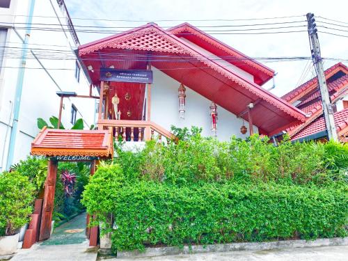 a house with a red roof and some bushes at Aphilapa Residence in Chiang Mai