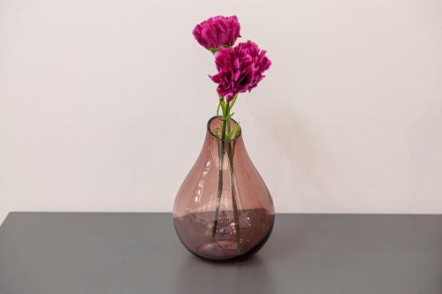 a vase with purple flowers in it on a table at Ioannina Central Apartment by SuperhostHub in Ioannina