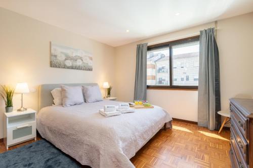 a bedroom with a large bed and a window at Bright & Spacious Flat by Host Wise in Porto