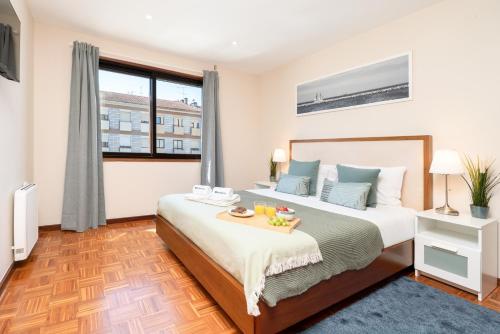a bedroom with a bed with a tray of food on it at Bright & Spacious Flat by Host Wise in Porto