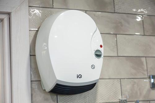 a white hair dryer on the wall of a bathroom at Ioannina Central Apartment by SuperhostHub in Ioannina