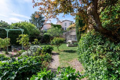un jardin avec une maison en arrière-plan dans l'établissement Le Jardin suspendu, à Grignan