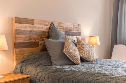 a bedroom with a bed with a wooden headboard and pillows at Casa em Cascais in Cascais