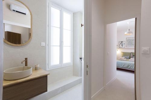 une salle de bain avec un lavabo et un miroir dans l'établissement 8 Rue Du Marché Forville by Halldis, à Cannes