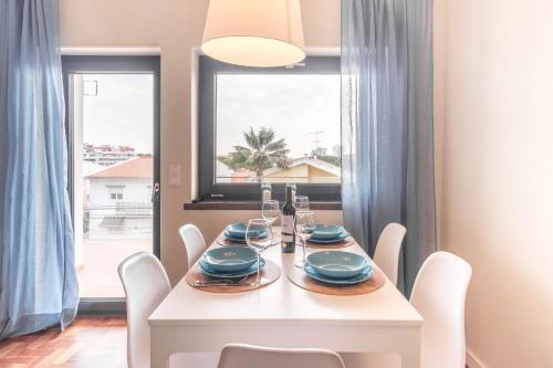 a dining room with a white table and chairs and a window at Casa em Cascais in Cascais