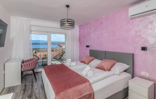 a bedroom with a large bed and a pink wall at Restaurant & Rooms Nino in Porat