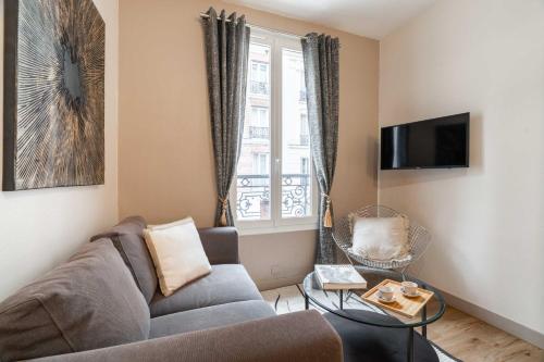 un salon avec un canapé et une fenêtre dans l'établissement Apartment near Porte de Versailles, à Paris