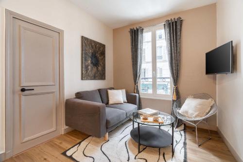 un salon avec un canapé et une table dans l'établissement Apartment near Porte de Versailles, à Paris