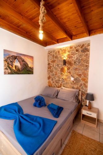 a bedroom with a bed in a stone wall at DIMIS ASOMATOS HOMES in Kos