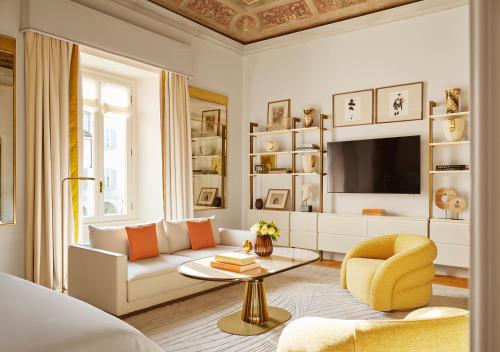 a living room with a couch and a tv at Four Seasons Hotel Milano in Milan