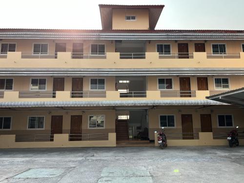 a building with two motorcycles parked in front of it at Jamjuree Place in Ban Si Than