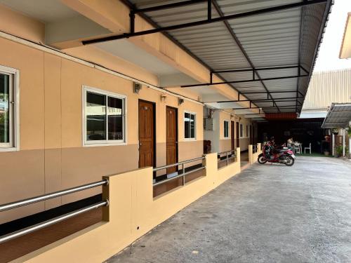 a building with a motorcycle parked inside of it at Jamjuree Place in Ban Si Than