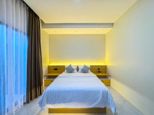 a bedroom with a white bed and a large window at De Luna Villa with private heated pool in Tegalharendong