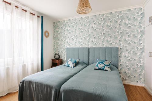 - une chambre avec un lit bleu et 2 oreillers bleus dans l'établissement Charmante maison pres plage et port, à Saint-Trojan-les-Bains
