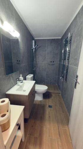 a bathroom with a sink and a toilet and a mirror at Dad's Studio in Kavala
