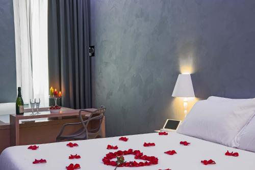 a bedroom with a bed with red roses on it at 7 Inn Spanish Steps in Rome