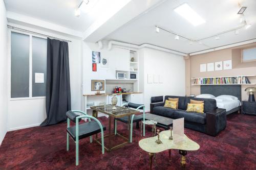 un salon avec un canapé et un lit dans l'établissement GuestReady - Artist Loft with a Vertical Garden, à Paris