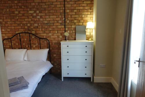 een slaapkamer met een bed en een bakstenen muur bij Unique, City-Center Location in Salisbury