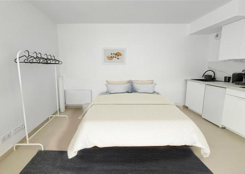 une chambre blanche avec un lit avec un tapis noir dans l'établissement Studio moderne avec terrasse privée et parking, à Poissy