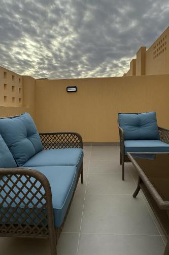 a room with two chairs and a bed and a table at Mountain view in AlUla