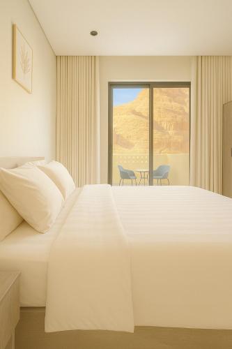 a hotel room with a large bed and a window at Mountain view in AlUla