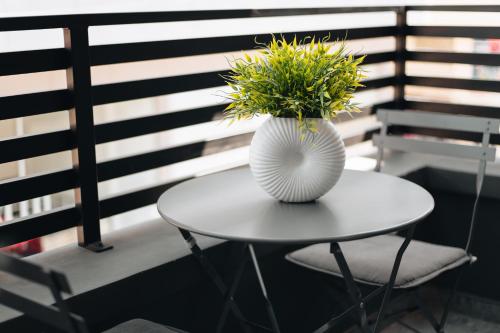 a white vase sitting on a table with a plant at Kition Urban Suite 1 in Larnaka