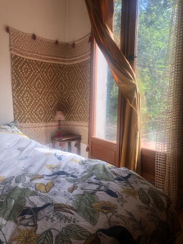 Ce lit se trouve dans une chambre dotée d'une fenêtre et d'un couvre-lit. dans l'établissement Le Jardin, à Rennes-les-Bains