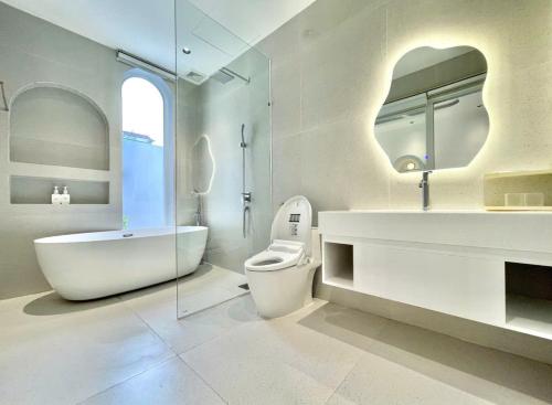 Un baño con bañera, inodoro y lavabo. en Villa Đà nẵng Lavender Luxury, en Da Nang