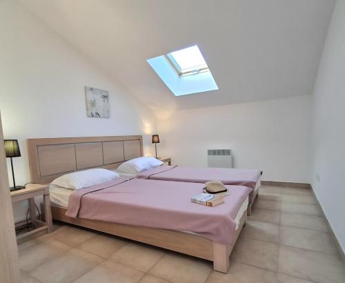 une chambre avec un lit et une lucarne dans l'établissement Villas MELODY - Appartement climatisé 4/6 pers, à Santa-Maria-Poggio