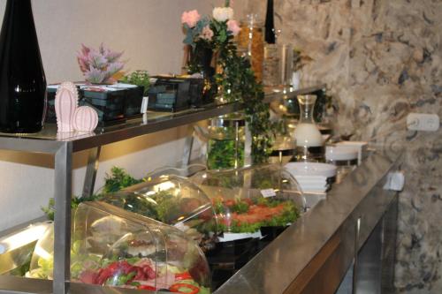 a buffet line in a restaurant with vegetables and flowers at Hotel Maximo in Pinneberg