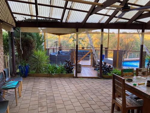a screened in patio with a table and chairs at Funday Farm Adelaide Hills in Norton Summit