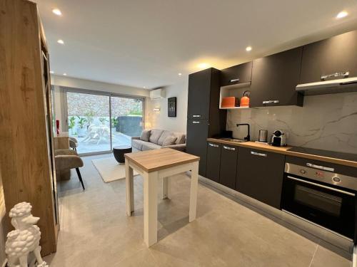 une cuisine avec une table et un salon dans l'établissement Renovated studio near beach, à Cannes