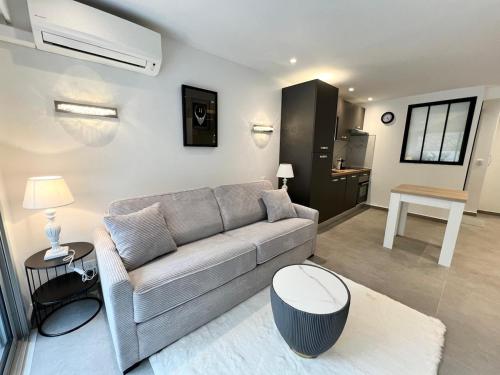 un salon avec un canapé et une table dans l'établissement Renovated studio near beach, à Cannes