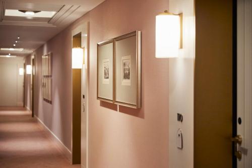 a hallway with paintings and pictures on the walls at Four Seasons Hotel Milano in Milan
