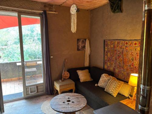 a living room with a couch and a table at Le Jardin in Rennes-les-Bains