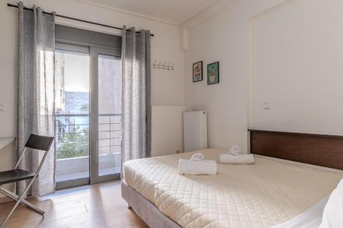 Un dormitorio con una cama grande y un balcón. en Elvita Apartments, en Atenas