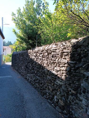 a stone retaining wall next to a road at Casa Bianca, Vista unica sul lago di Como in Dervio