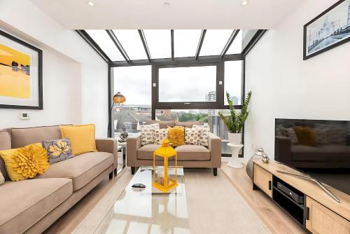 a living room with two couches and a tv at Bright 3 Bed 2 Bath with Air Con in Clerkenwell - Pass the Keys in London