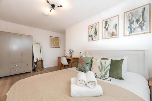 a bedroom with a large bed with two towels at Bright 3 Bed 2 Bath with Air Con in Clerkenwell - Pass the Keys in London