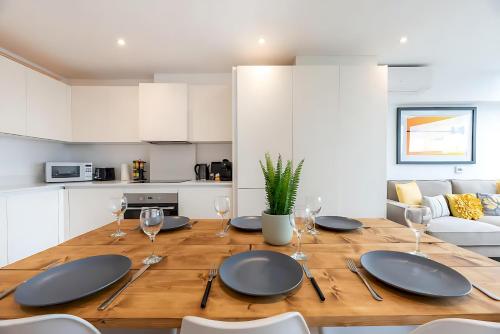 a dining room with a wooden table with wine glasses at Bright 3 Bed 2 Bath with Air Con in Clerkenwell - Pass the Keys in London