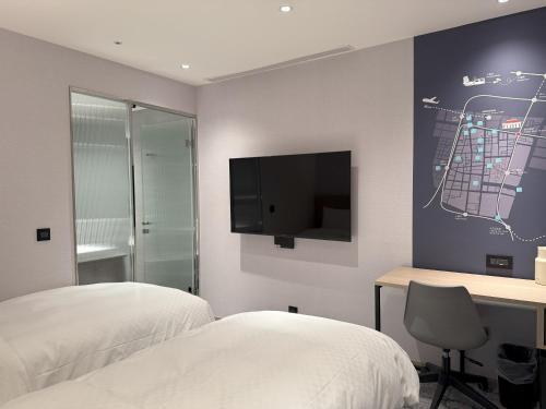 una camera con 2 letti, una scrivania e una TV di Tango Inn Taipei Kaifong a Taipei