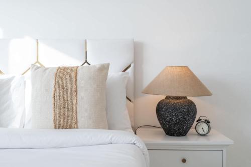 a bedroom with a bed with a lamp on a nightstand at Beautifully Furnished Studio with Skyline Views in Dubai Marina