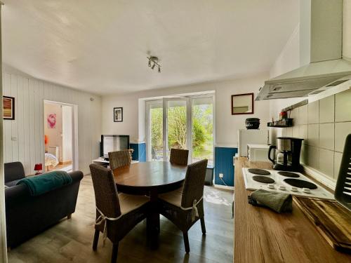 une cuisine et une salle à manger avec une table et des chaises dans l'établissement Appart' Basly - avec terrasse à 7km des plages, à Basly