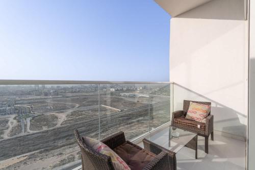 a room with two chairs and a large glass window at Beautifully Furnished Studio with Skyline Views in Dubai Marina