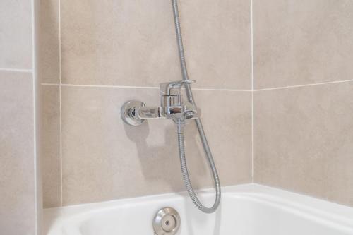 a shower with a shower head in a bathroom at Beautifully Furnished Studio with Skyline Views in Dubai Marina
