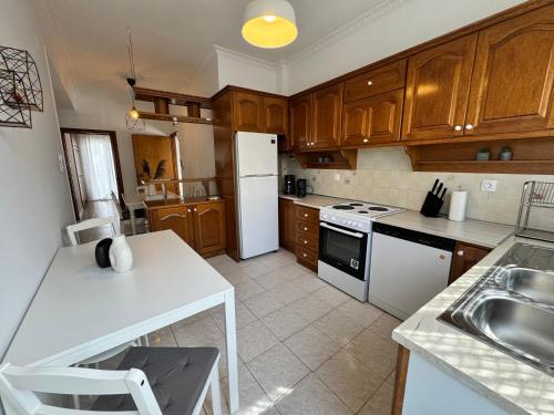 a kitchen with wooden cabinets and a white refrigerator at Evelyn House in Samos