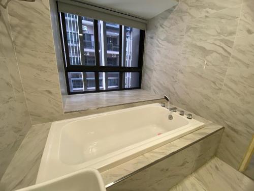 a white bath tub in a bathroom with a window at Imperio Residence Melaka by Jeffery Lam Home Management in Melaka