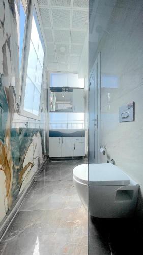 a bathroom with a toilet and a glass shower at Ozy Houses Center in Kaş