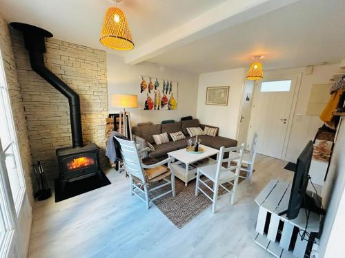- un salon avec un canapé, une table et une cheminée dans l'établissement 520 Le Petit Phare Village House, à Saint-Clément-des-Baleines